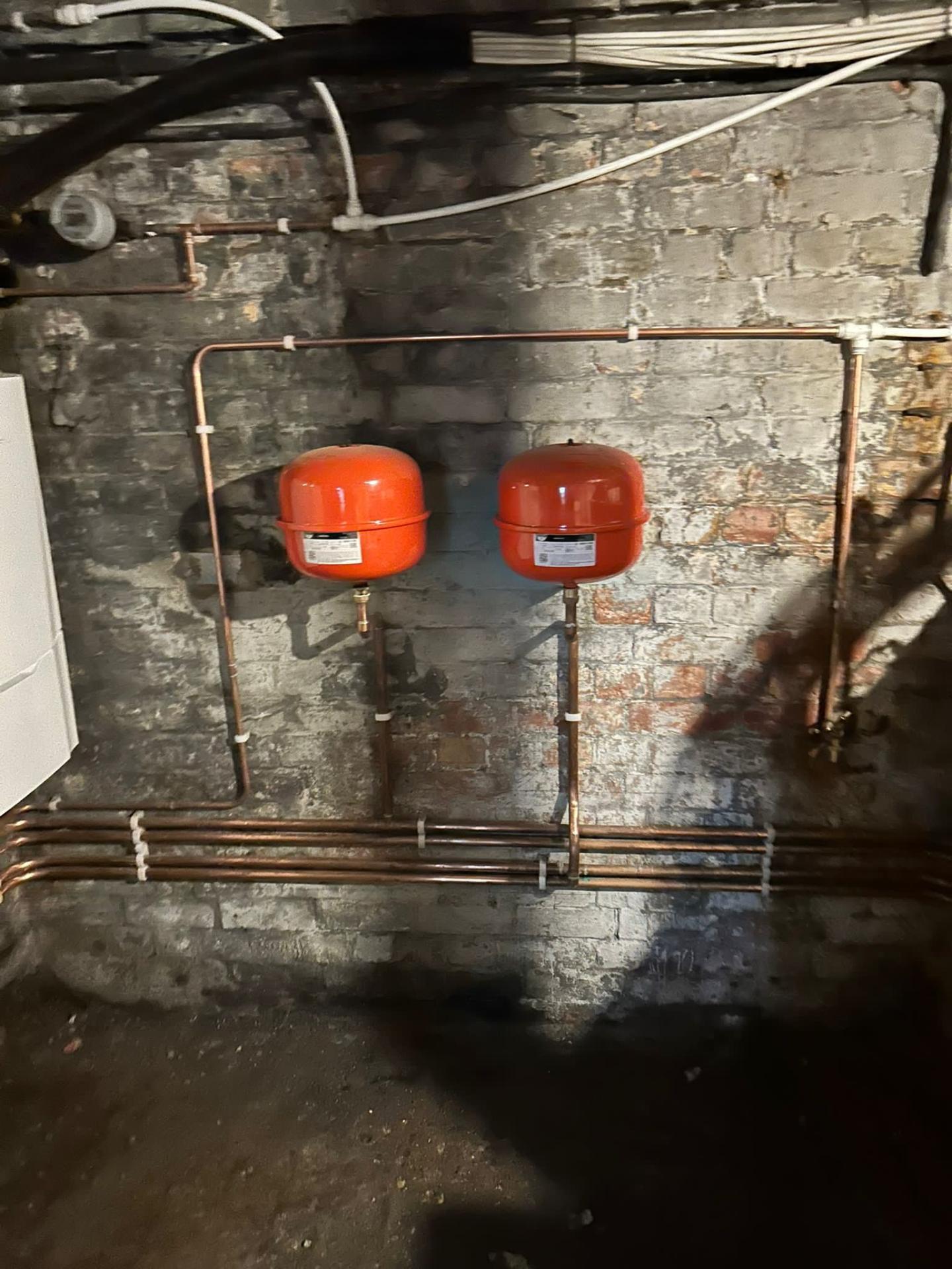 Close-up of clean copper pipework with brass isolation valves on a UK utility wall — Reactive emergency plumbing repair